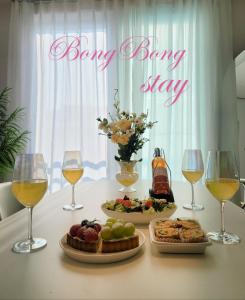 a table with two plates of food and wine glasses at Bongbong Stay in Seoul