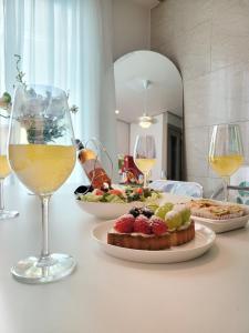 a table with a plate of food and glasses of wine at Bongbong Stay in Seoul
