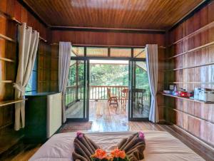 sypialnia z łóżkiem w pokoju z werandą w obiekcie Koh Jum Serenity Resort w mieście Koh Jum
