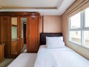 a bedroom with a white bed with a window at Amazing 1BR Apartment Gateway Pasteur By Travelio in Bandung +18 photos