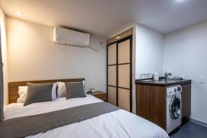 ソウルにあるBeyond Residence Jongnoのベッドルーム1室(ベッド1台、洗濯機付)
