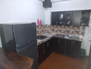 a kitchen with a black refrigerator and a sink at Hermoso Apartamento in Quimbaya