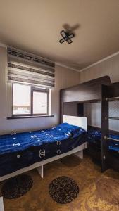 a bedroom with a bed and a ceiling fan at Khan Guest House in Engilʼchek