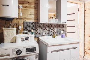 a kitchen with a washing machine and a sink at Khan Guest House in Engilʼchek +58 photos