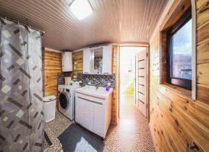 a kitchen with a washer and dryer in a house at Khan Guest House in Engilʼchek +52 photos
