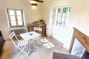 Pokój ze stołem, krzesłami i drzwiami w obiekcie Petite maison charmante à Cons-la-Grandville avec terrasse et jardin w mieście Cons-la-Grandville +5 zdjęć