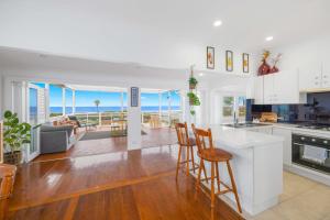 a kitchen and living room with a view of the ocean at Sun Catcher - ocean views, walk to beach, lake, cafés, shops in Lake Cathie