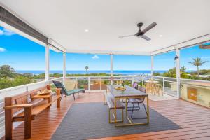 a patio with a table and chairs on a deck at Sun Catcher - ocean views, walk to beach, lake, cafés, shops in Lake Cathie
