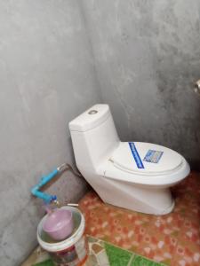 a bathroom with a white toilet in a room at Abu Sea Man House in Ko Lanta Yai