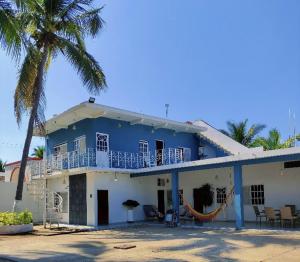 a blue and white house with a palm tree at Casa Punta Perula in Pérula