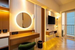 a room with a mirror and a green chair in it at Tokyo Riverside Apartemen PIK 2- Kaito Inn Royale in Muara