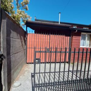 un cancello nero davanti a un edificio rosso di Casa Equipada Puerto Varas a Puerto Varas