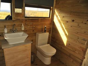 a small bathroom with a toilet and a sink at Kuierbos in Gouritzmond