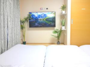 a bedroom with a flat screen tv on the wall at 大阪西九条stay屋上BBQ可 in Osaka