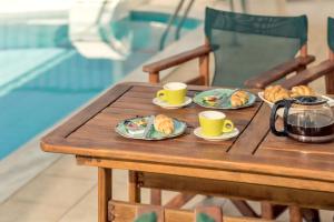 プラノスにあるElegant Villa in Planos + Private Pool.の木製テーブル(2杯、皿付)
