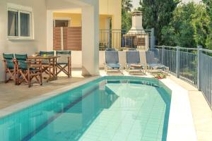 プラノスにあるElegant Villa in Planos + Private Pool.の家の隣にテーブルと椅子付きのスイミングプール