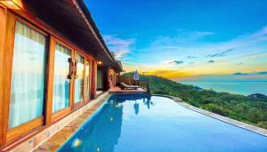 einen Pool vor einem Haus mit Aussicht in der Unterkunft Santhiya Koh Phangan Resort and Spa in Thong Nai Pan Noi