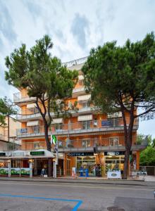 un bâtiment avec deux arbres devant lui dans l'établissement Residence Mariavittoria, à Lido di Jesolo
