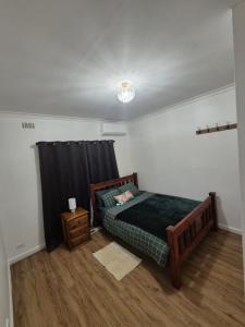una camera con letto e tenda nera di Nice and comfy home in Geelong a Newtown and Chilwell