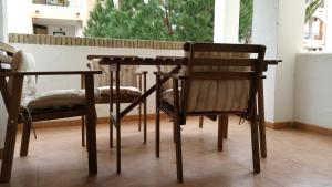 サアラ・デ・ロス・アトゥネスにあるApartamento Atlanterra Playaの木製テーブルと椅子2脚
