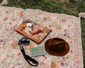 un sombrero y un plato de comida en una manta en Tiny Mowgli, en Bulliac
