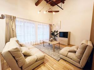 a living room with a couch and a tv at SSr大和町1丁目 in Tokyo