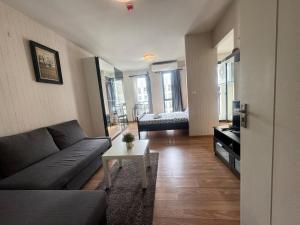 a living room with a couch and a table at Sunlit Nest Sukhumvit in Ban Khlong Samrong +24 photos