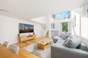 a living room with a couch and a table at Noahs Beach House - at Flynns in Port Macquarie