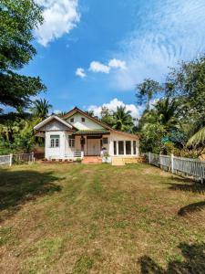 une maison blanche avec une clôture devant une cour dans l'établissement MaMa Resort Thongsala Koh Phangan, à Thongsala