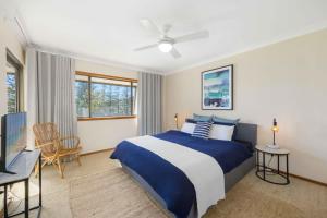 a bedroom with a blue and white bed and a desk at Taranaki Penthouse - wonderful in Port Macquarie