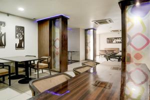 a dining room with a wooden table and chairs at Townhouse Anand Formerly Hotel The Maison in Anand