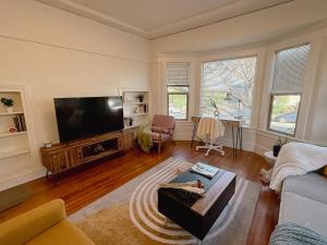 a living room with a flat screen tv and a couch at Bright, Modern & Artsy Space in Oakland