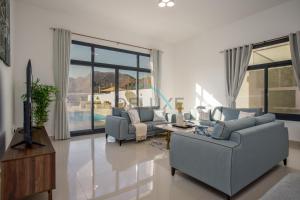 a living room with two couches and a tv at Serene 3BR Villa with Private Pool in Al Dana Island, Fujairah by Deluxe Holiday Homes in Fujairah