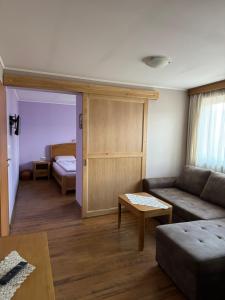 a living room with a couch and a bed at Guest House Roden Dom in Koprivshtitsa