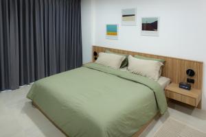 une chambre avec un grand lit avec des draps verts dans l'établissement Peaceful Townhouse in Sathorn Near Saint Louis BTS, à Yan Nawa