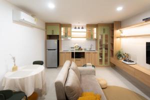 une cuisine et un salon avec un canapé et une table dans l'établissement Peaceful Townhouse in Sathorn Near Saint Louis BTS, à Yan Nawa