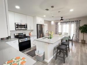 a kitchen with white cabinets and a kitchen island with a stove at Pool House Newly Remodeled 3bed 3bath Near DT Summerlin and Red Rock in Las Vegas