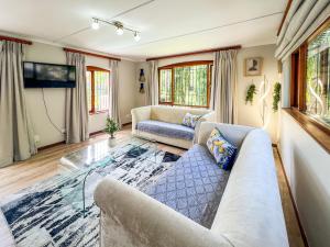 a living room with a couch and a tv at Spacious George self catering apartment for families, golfers, business travellers and couples 1 queen bed 2 sleeper couches in George