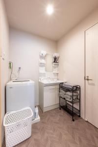a white bathroom with a sink and a toilet at BPhouse森ノ宮第二 in Osaka