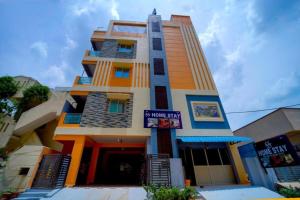 ティルパティにあるS S Homestay Luxury 2BHK and 1BHK AC Apartments Near Tirupati Railway Station and Balaji Bus Standの前に看板がある高い建物