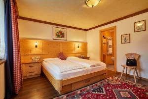 a bedroom with a large bed and a bathroom at Hotel Pensione Veneranda in Corvara in Badia +24 photos