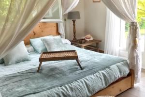a bedroom with a bed with a table on it at Maison d'exception à Arbonne, piscine privée saisonnière. in Arbonne