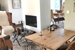 a living room with a wooden table and a tv at Maison d'exception à Arbonne, piscine privée saisonnière. in Arbonne