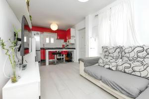 a living room with a couch and a kitchen at Charming House in Chiclana de la Frontera with Terrace in Chiclana de la Frontera