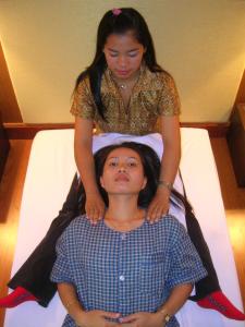 a girl standing on top of a woman on a bed at Hatyai Golden Crown Hotel in Hat Yai