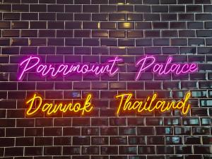 SadaoParamount Palace Hotel Dannok的砖墙上的一个 ⁇ 虹灯标志,字的支付依赖性受到抑制