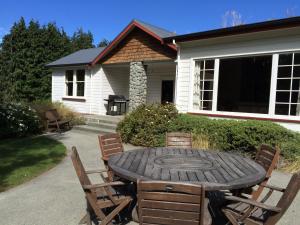 a wooden table and chairs in front of a house at Mt John Homestead in Lake Tekapo