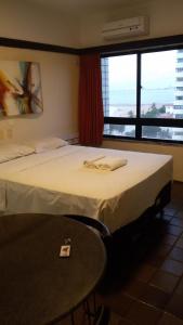 a hotel room with a bed and a table and a window at Vista Maravilhosa 706 in Fortaleza