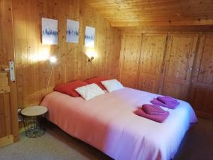 une chambre avec un grand lit dans une pièce en bois dans l'établissement Chalet Paolina proche le Grand Bornand et la Clusaz, à Glières-Val-de-Borne