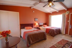 a bedroom with two beds and a table and a window at Harmony Motel in Twentynine Palms +44 photos